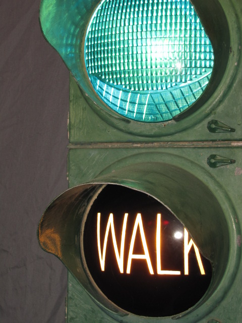 Early pedestrian accommodation, first with the green lens designed to throw some light downward, then with the separate “Walk” lens